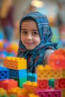 A young girl smiles while playing with legos photo