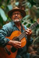 An older man playing an acoustic guitar in the jungle photo