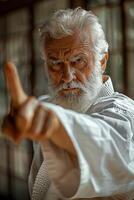 An old man in karate gear pointing at something photo