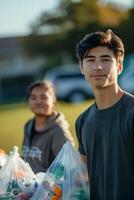 A young man holding a bag of trash photo