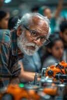 An older man with glasses and a beard working on a robot photo