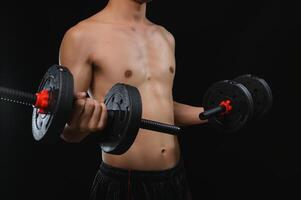 Young Man Strength Training with Dumbbells in a Dark Gym Environment photo