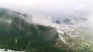 Clouds above green mountain fields with snow and grass, panorama hillside, misty view, scenery grass, natural cloud forest video