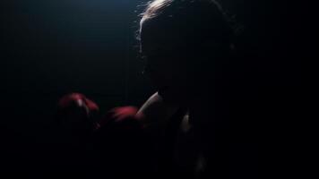 Strong female fighter practicing fast and strong hand strikes, shadow boxing in an abandoned room in slow motion video