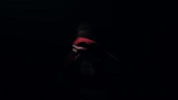 A boxer in a dark room with a light behind him practicing shadow boxing and practicing his punches. video