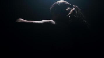 fort femme combattant pratiquant vite et fort main grèves, ombre boxe dans un abandonné pièce dans lent mouvement video