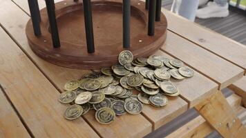 A rustic wooden table with coins creates a warm, inviting scene. Creative video