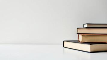 A minimalistic and modern composition of stack of books neatly arranged on the right side against a clean white background, with empty space on the left for text photo