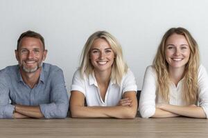 Smiling Adults in Casual Attire at a Wooden Table photo