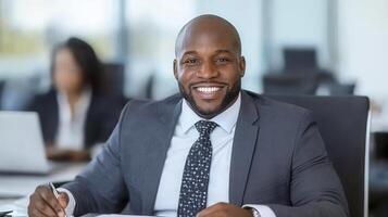 Smiling Businessman in Gray Suit Writing at Desk photo