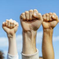 Three Fists Raised Against a Blue Sky photo