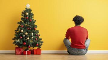 Man Sitting Alone Near Decorated Christmas Tree photo