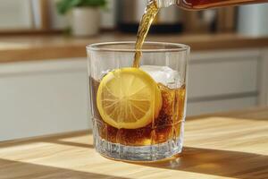 Amber Beverage Poured into Glass with Ice and Lemon Slice photo