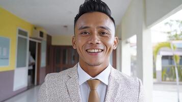 Smiling Young Man in Beige Blazer and Gold Tie photo