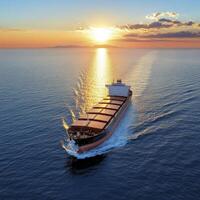 Cargo Ship at Sunset on Calm Ocean photo