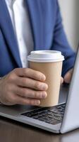 Man Working on Laptop with Coffee Cup photo