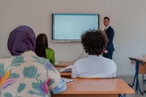 A university teacher using a smart board to explain a lesson in the classroom. photo