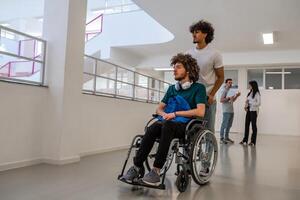 Group of diverse college students in university hallway, a classmate pushing a friend in a wheelchair as they walk down the school corridor or caregiver walks with a patient through hospital corridor. photo