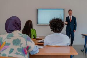 A university lecturer using a smart board to explain a lesson in the classroom. photo