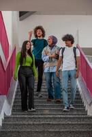 A group of happy diverse college students hanging out they are talking with each other while walking in the university hallway. photo