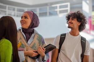 A group of happy diverse college students hanging out they are talking with each other while walking in the university hallway. photo