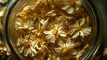A jar full of dried flowers sitting on a table photo