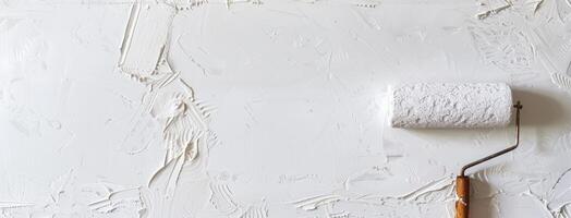 A white wall with a roll of paint and a paint roller photo