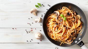 Spaghetti with mushrooms and tomatoes in a pan photo