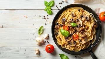 Spaghetti with mushrooms and tomatoes on a wooden table photo