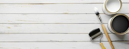 A paint can, paint brush and paint roller on a white wooden table photo