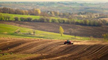 Tractor plowing field in countryside photo
