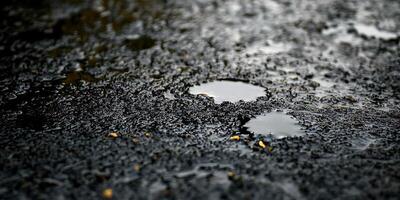 A puddle of water on the ground with a small hole in it photo