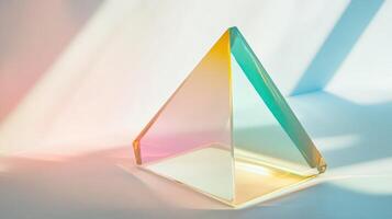 A glass pyramid shaped object with a rainbow colored background photo