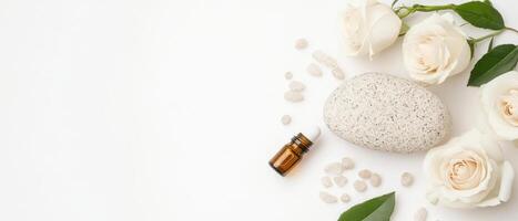Aesthetic spa arrangement with fresh roses, essential oil, and stones. This serene setup evokes relaxation and tranquility photo