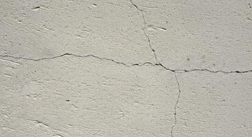 A crack in the concrete wall with a crack in the middle photo