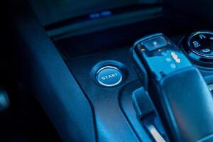 Close-up of a car start engine button and central console with gear shift, illustrating modern vehicle interior, smart controls, and push-button ignition technology photo