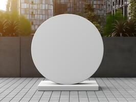 A white round sign on a pedestal in front of a city photo