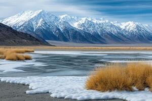 A snowy mountain range with grass and snow photo