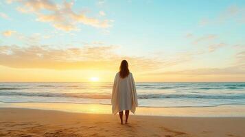 woman stands on beach at sunset, wrapped in flowing cape, reflecting on life photo