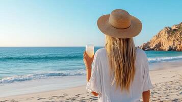 woman in sunhat enjoys drink by beach, embracing relaxation photo