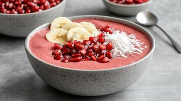 vibrant red smoothie bowl topped with banana, pomegranate, and coconut photo