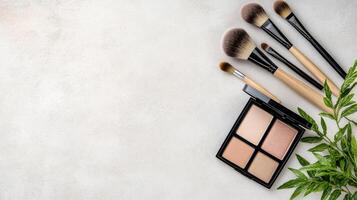 Makeup brushes and palettes arranged with greenery for fresh look photo