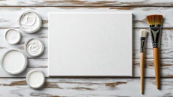 Blank canvas with brushes and paint jars ready for creativity photo
