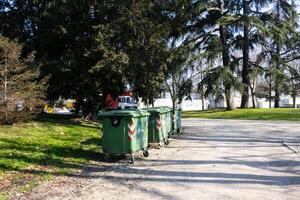 green color garbage cans in the park on the background of the forest photo