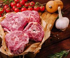 Fresh meat displayed with vegetables on a rustic wooden table photo