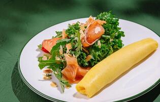 Fresh salad with smoked salmon and egg wrap on a plate photo