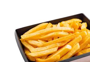 Crispy golden fries served in a black container on a white background photo