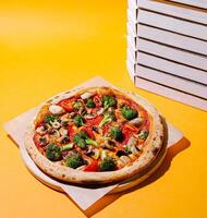 Freshly baked veggie pizza surrounded by empty boxes photo