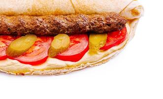 Delicious wrap filled with meat, fresh vegetables, and sauce photo