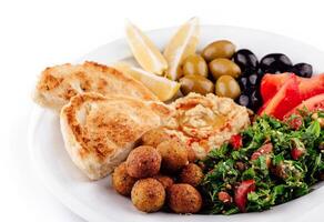 Plate presenting a colorful and tasty middle eastern mezze platter with various dips and salads closeup photo